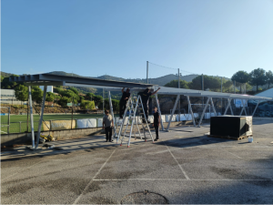 Operarios de Impulso Solar montando los paneles fotovoltaicos en la marquesina en parquing municipal en Tiana.